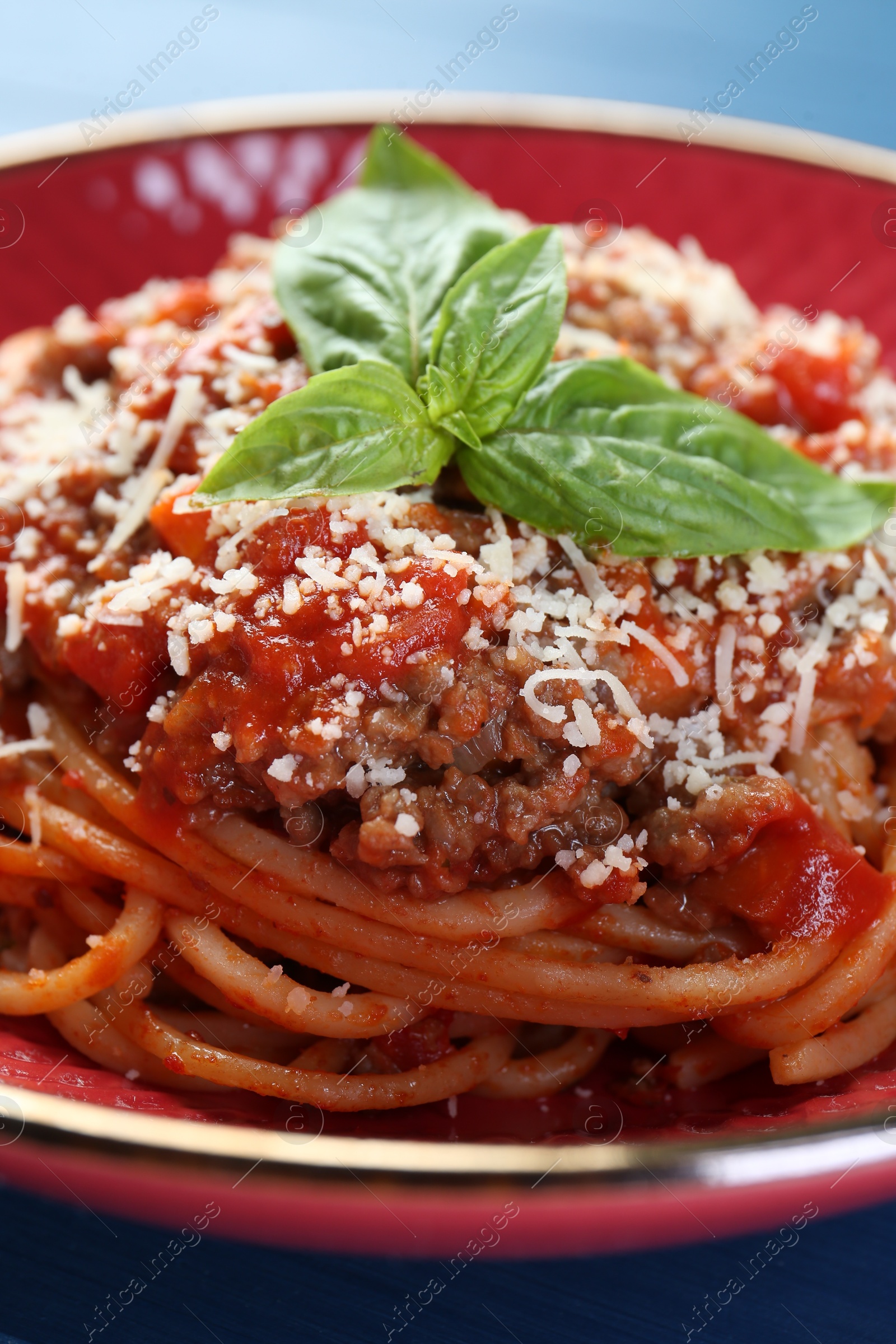 Photo of Delicious pasta bolognese with basil on table, closeup