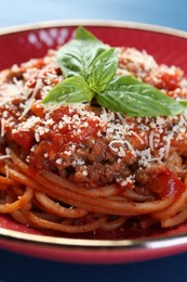 Photo of Delicious pasta bolognese with basil on table, closeup