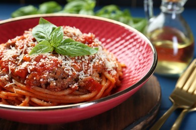 Photo of Delicious pasta bolognese with basil on table, closeup