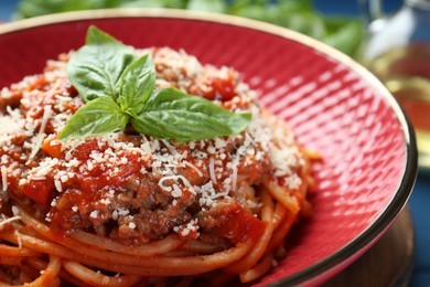 Photo of Delicious pasta bolognese with basil on table, closeup