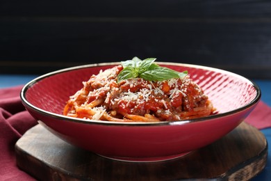 Photo of Delicious pasta bolognese with basil on table, closeup