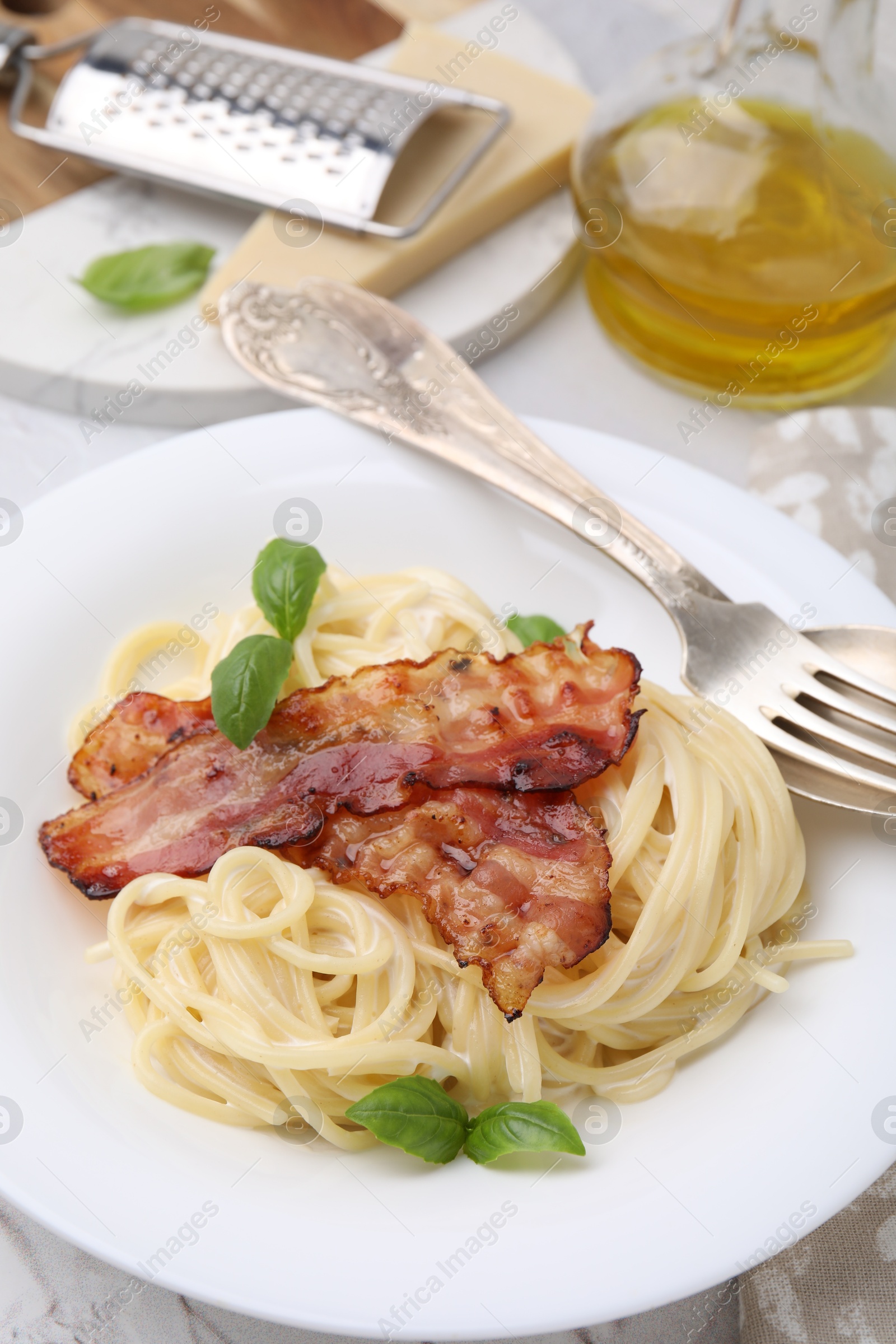 Photo of Delicious pasta Carbonara and cutlery on table, closeup