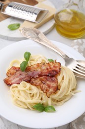 Photo of Delicious pasta Carbonara and cutlery on table, closeup