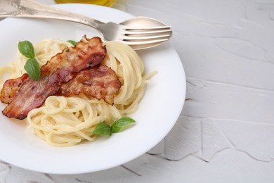 Photo of Delicious pasta Carbonara served on light textured table, closeup