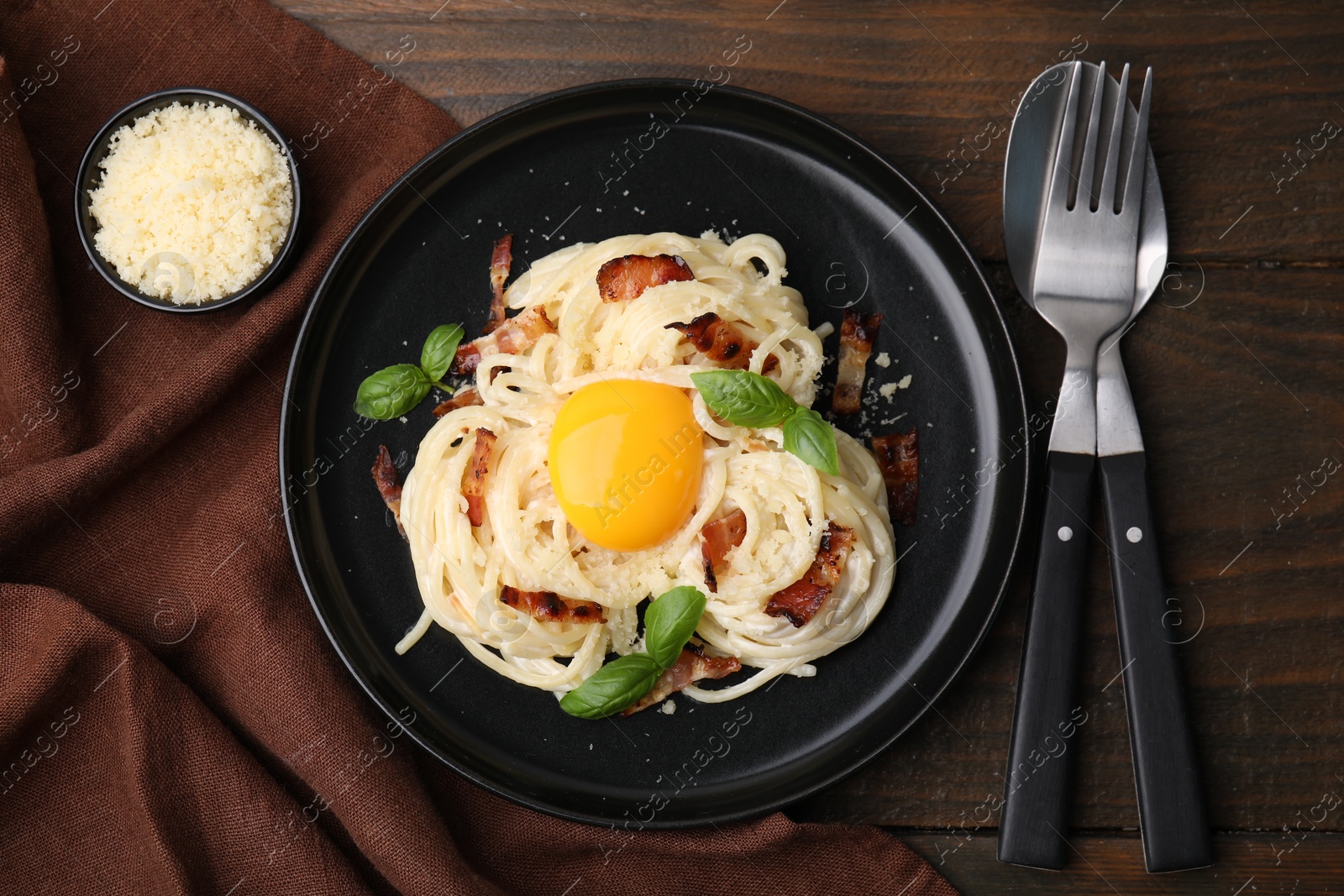 Photo of Delicious pasta Carbonara served on wooden table, flat lay