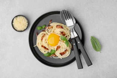 Photo of Delicious pasta Carbonara served on light gray table, flat lay