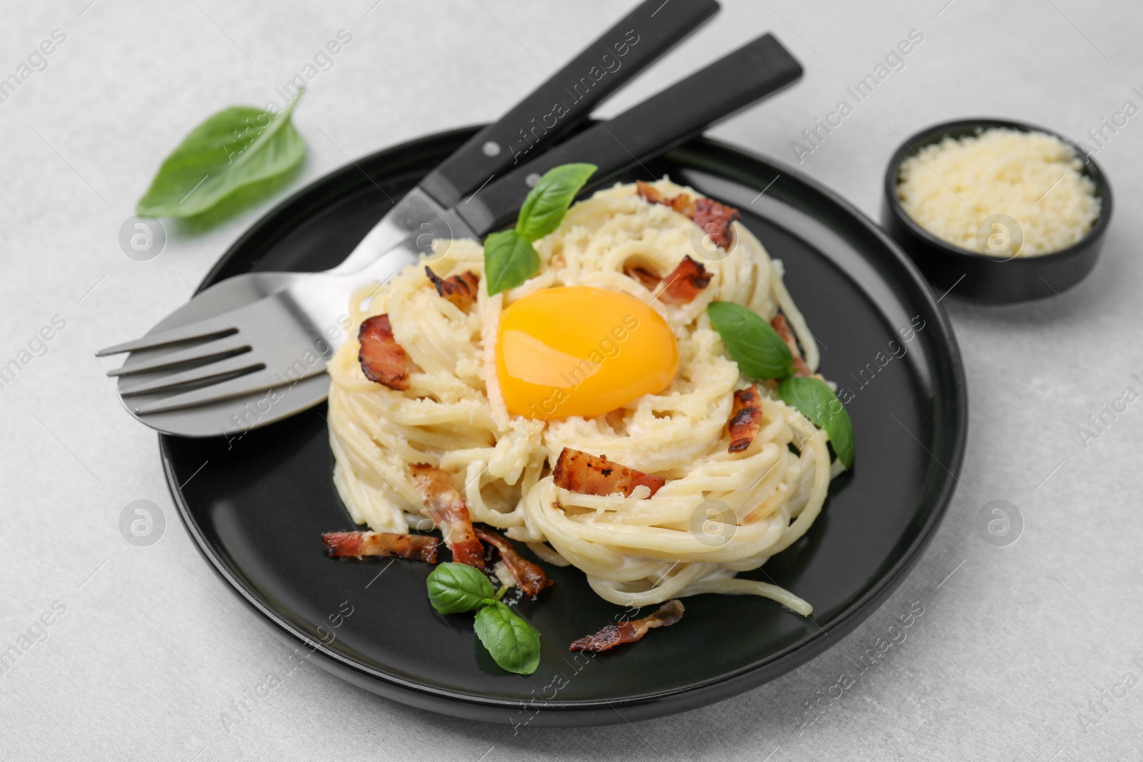 Photo of Delicious pasta Carbonara served on light gray table, closeup