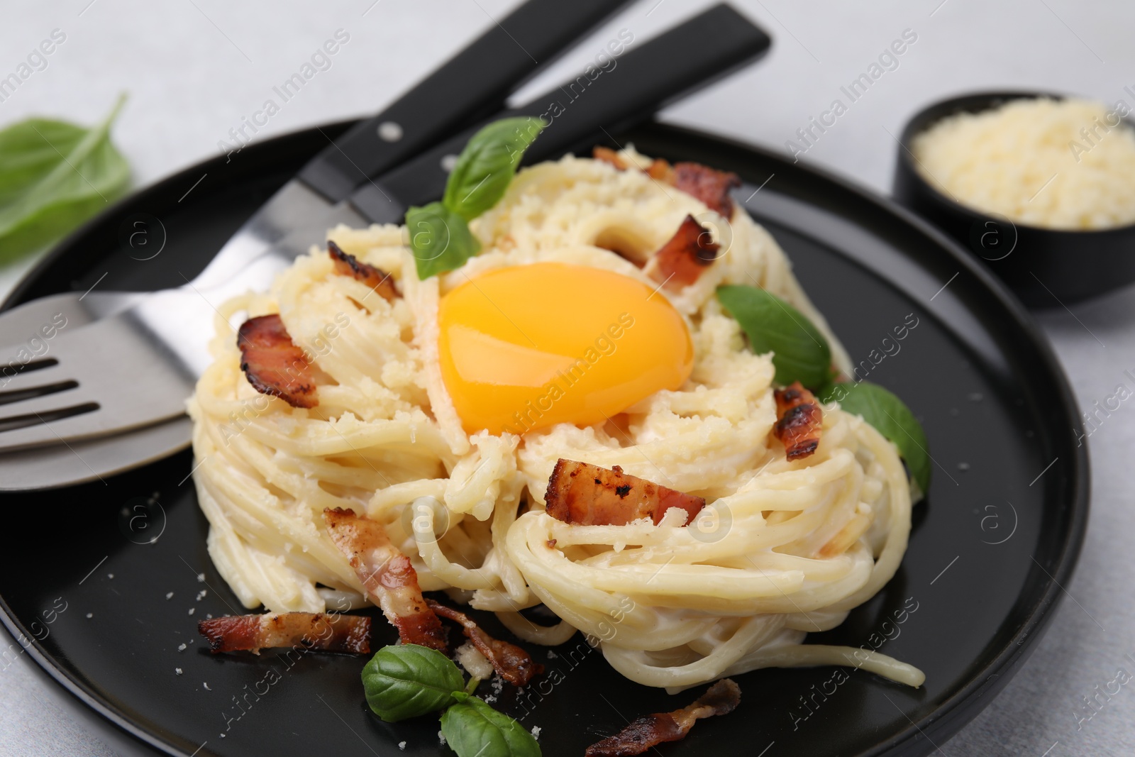 Photo of Delicious pasta Carbonara served on light gray table, closeup