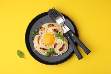 Photo of Delicious pasta Carbonara served on yellow table, top view