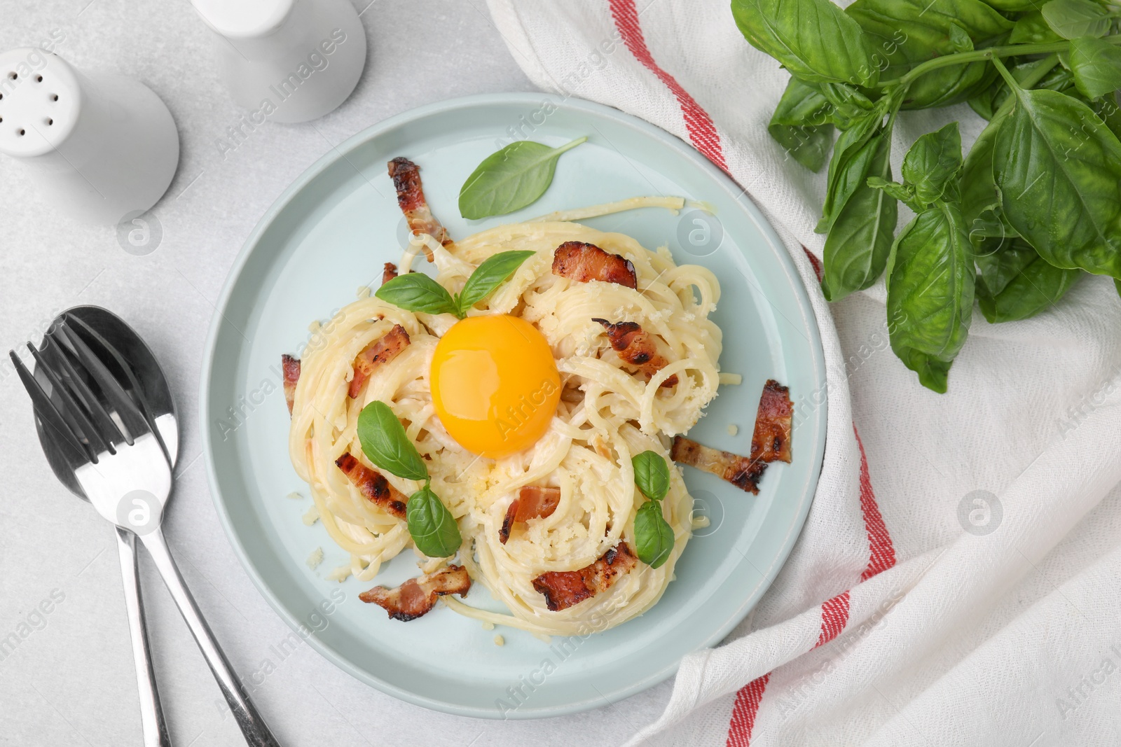 Photo of Delicious pasta Carbonara served on light gray table, flat lay