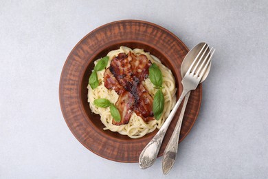 Delicious pasta Carbonara served on light gray table, top view