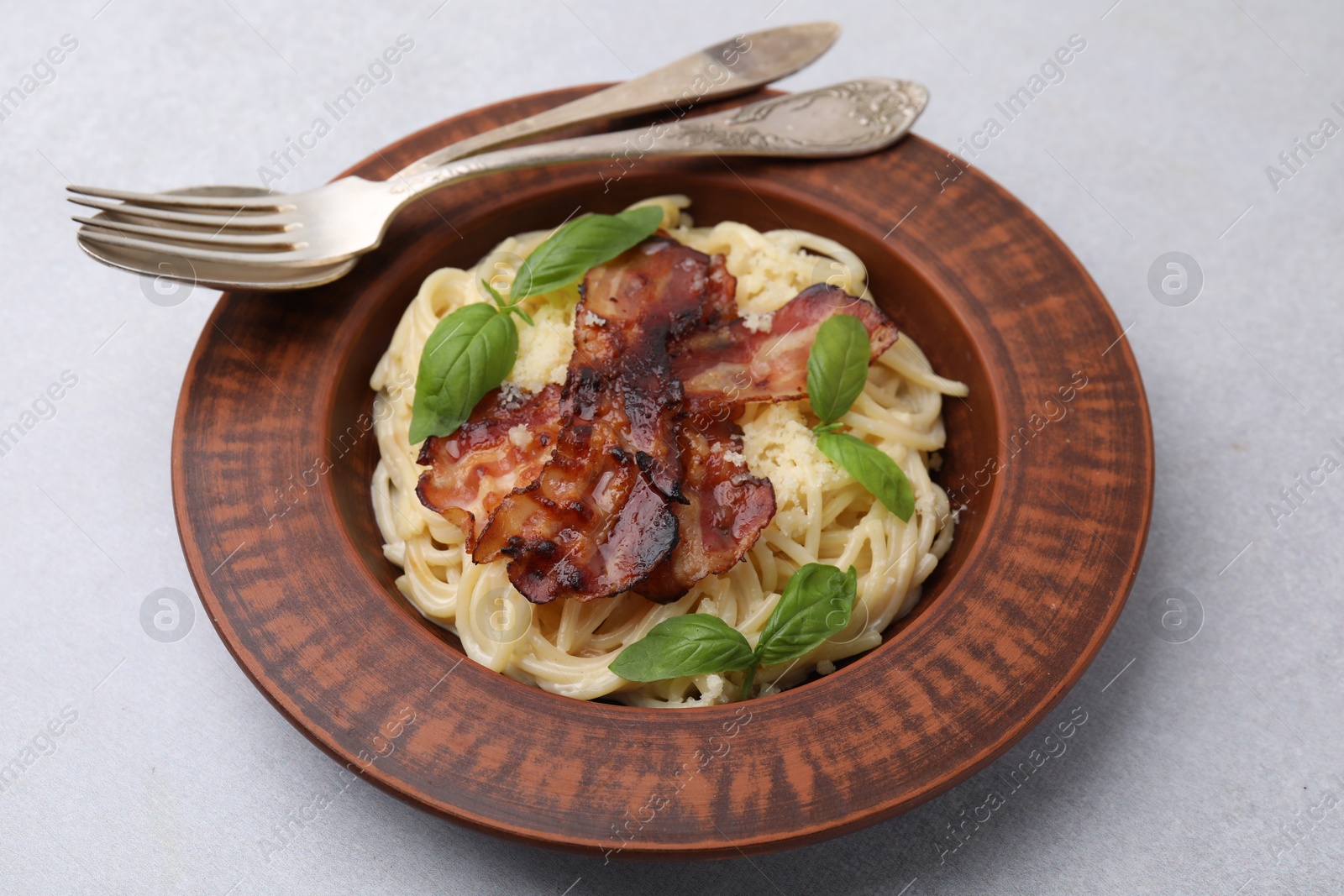 Photo of Delicious pasta Carbonara served on light gray table, closeup