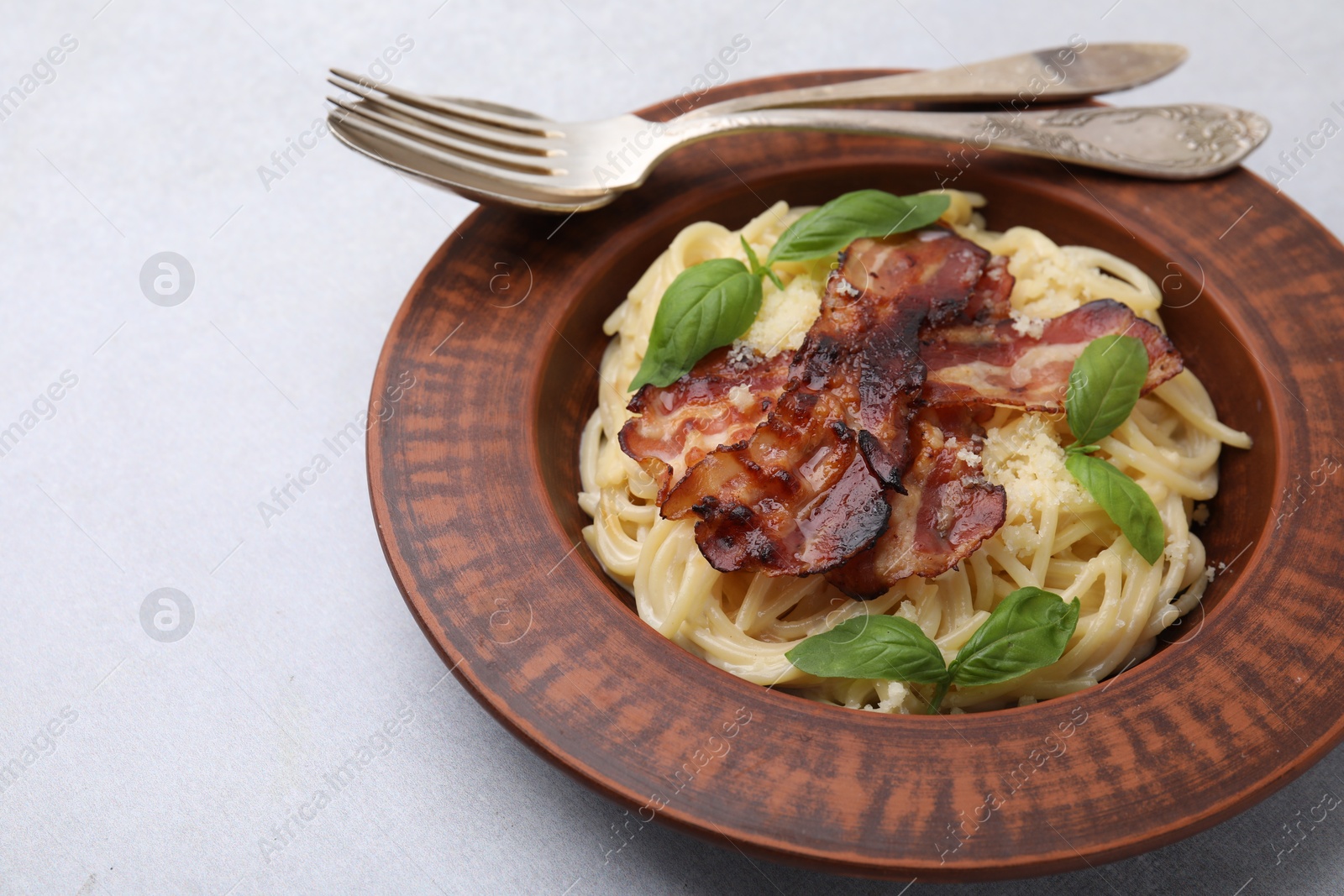 Photo of Delicious pasta Carbonara served on light gray table, closeup