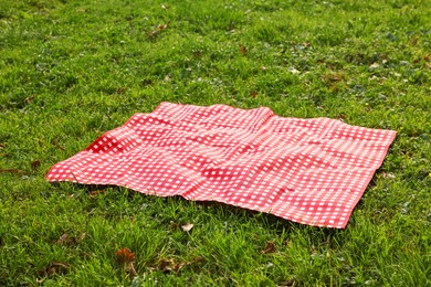 One checkered picnic tablecloth on green grass