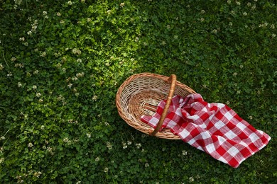 Photo of One picnic wicker basket on green grass, top view. Space for text