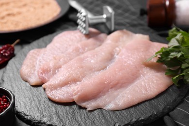 Making schnitzel. Raw meat chops on dark table, closeup