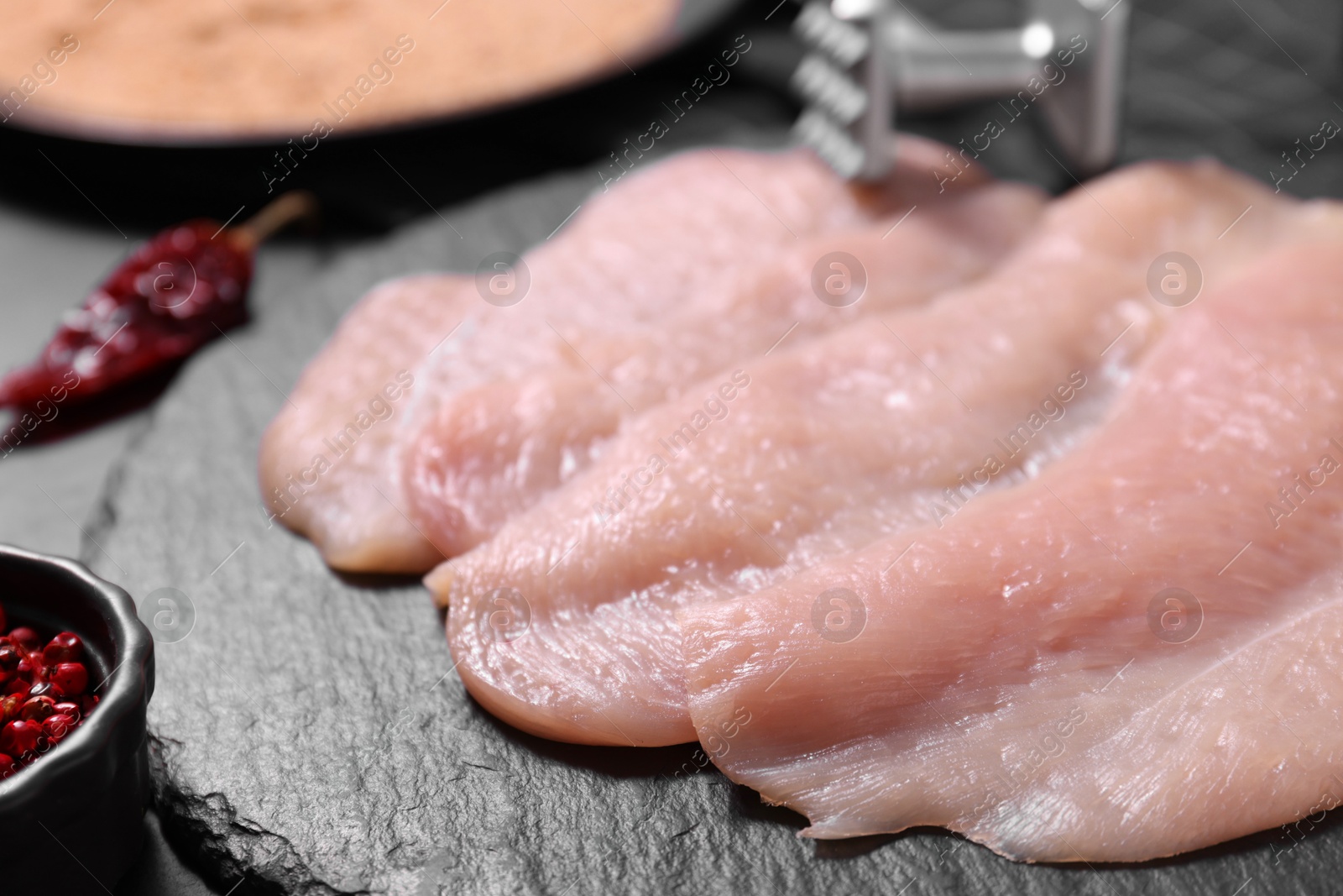 Photo of Making schnitzel. Raw meat chops on dark table, closeup