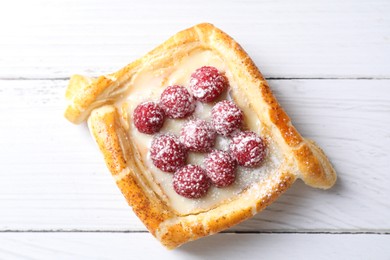 Tasty puff pastry with raspberries on white wooden table, top view