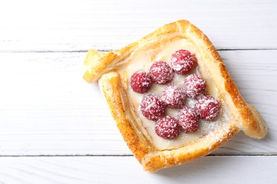 Photo of Tasty puff pastry with raspberries on white wooden table, top view. Space for text