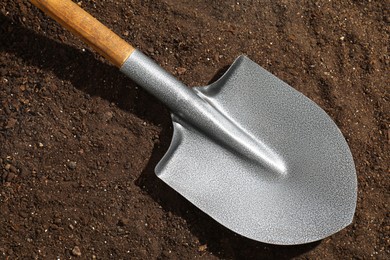 Photo of Metal shovel on pile of soil, top view