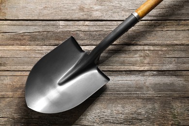 Photo of Metal shovel on wooden table, top view