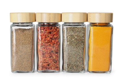 Photo of Different spices in glass jars isolated on white