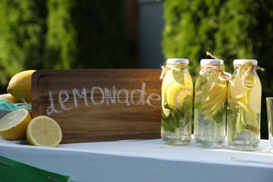 Lemonade stand with refreshing drink and fresh fruits in park