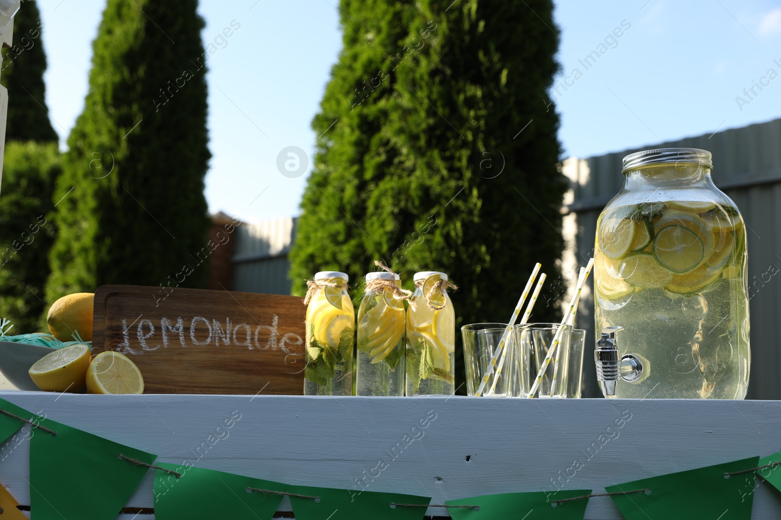 Photo of Lemonade stand with refreshing drink and fresh fruits in park