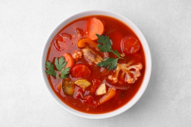 Delicious homemade stew in bowl on light table, top view