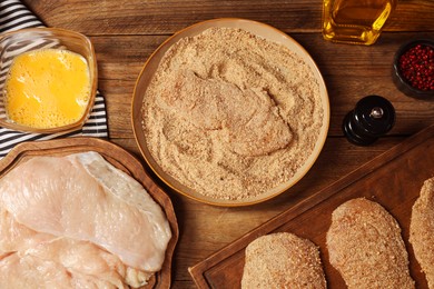 Making schnitzels. Raw meat and other ingredients on wooden table, flat lay