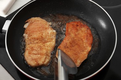 Schnitzels cooking in frying pan on stove, top view