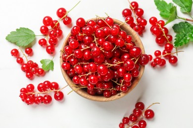 Photo of Fresh red currant berries in bowl on white table, top view