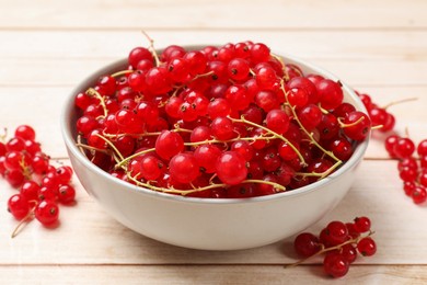 Photo of Fresh red currant berries in bowl on white wooden table, closeup