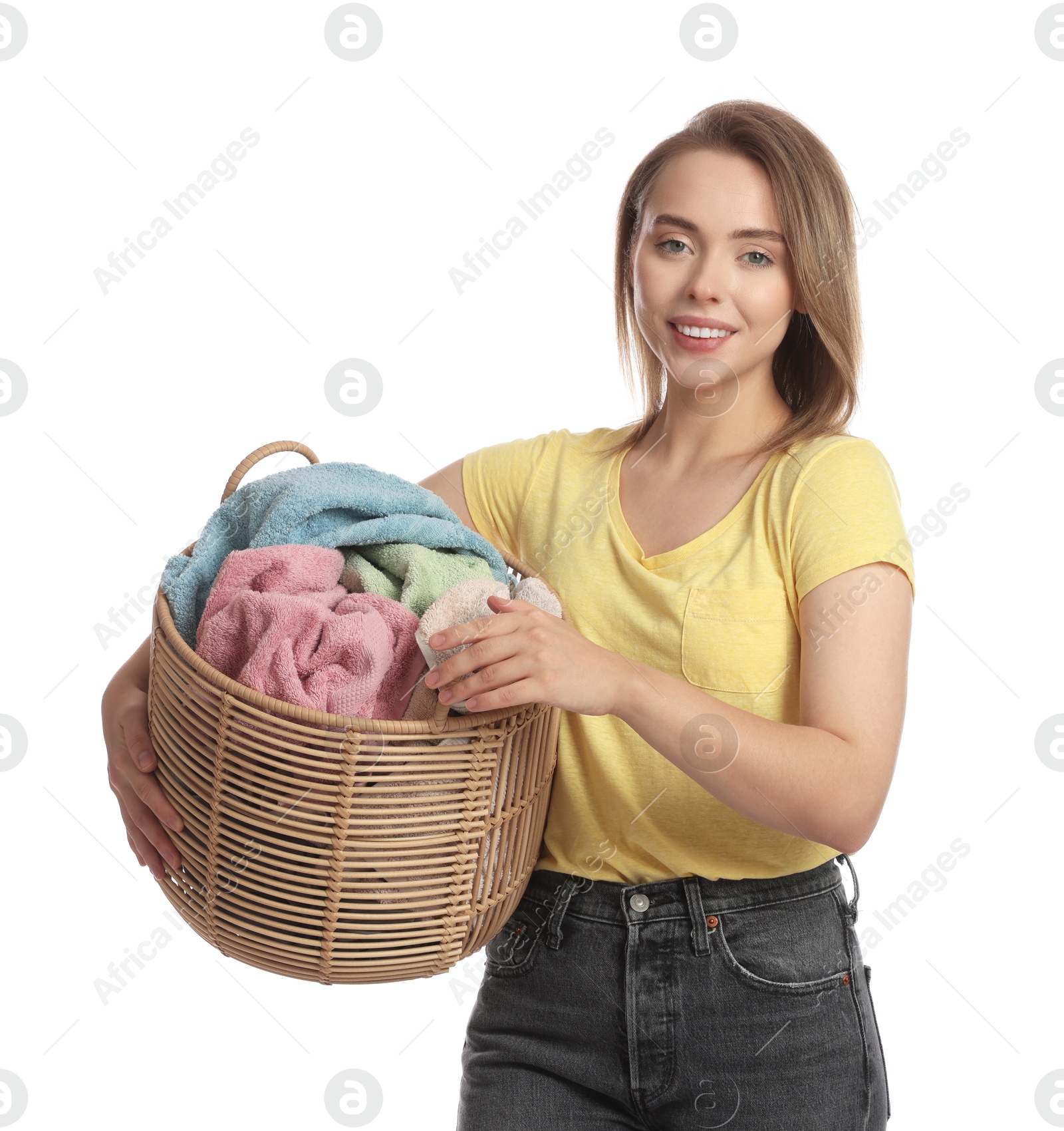 Photo of Happy young housewife with basket full of laundry on white background