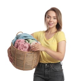 Photo of Happy young housewife with basket full of laundry on white background