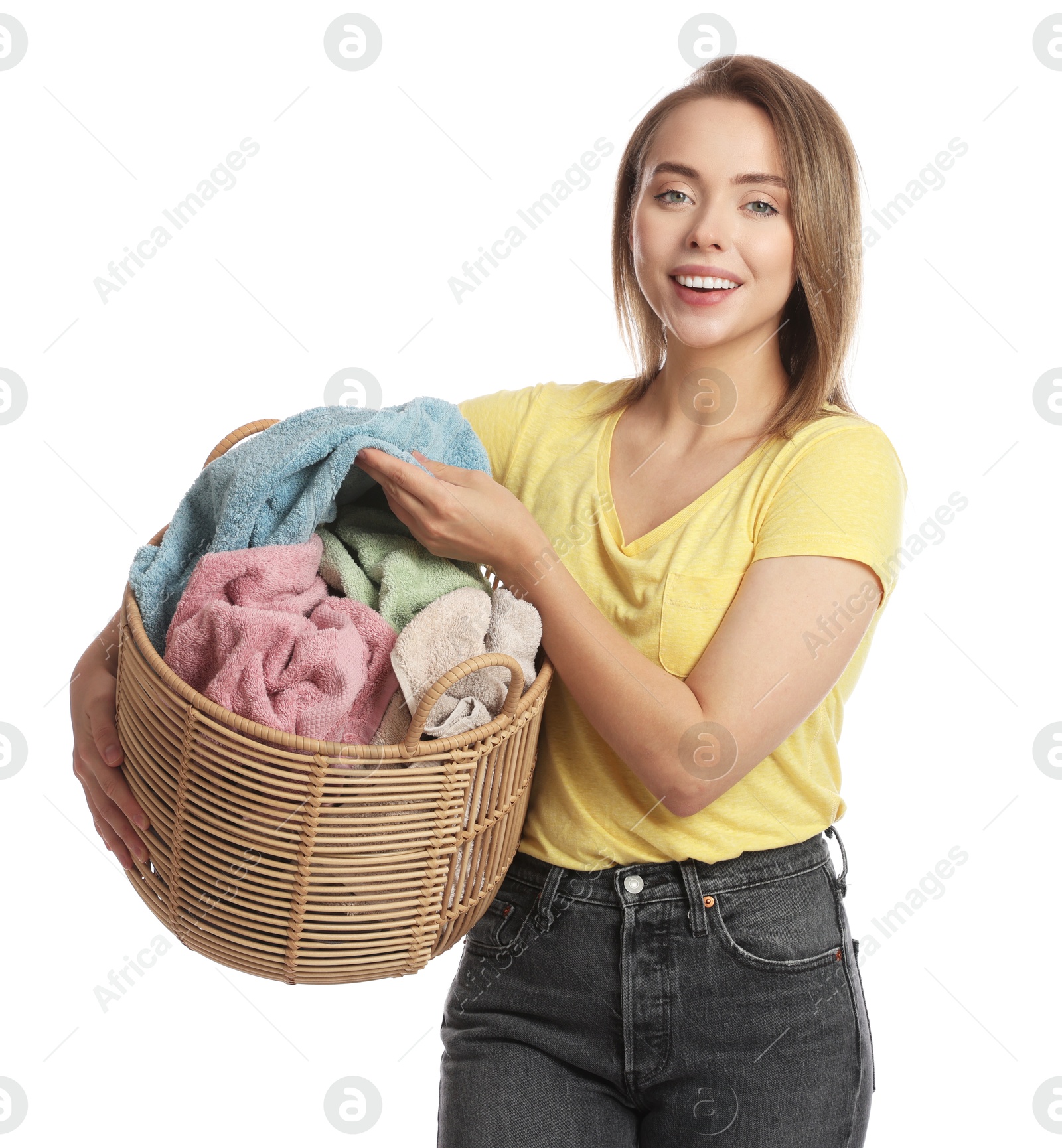 Photo of Happy young housewife with basket full of laundry on white background