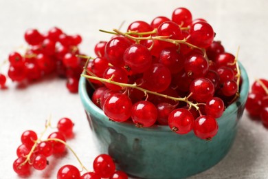 Photo of Fresh red currant in bowl on light table, closeup