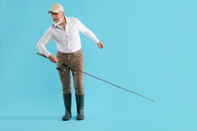 Photo of Fisherman with rod on light blue background