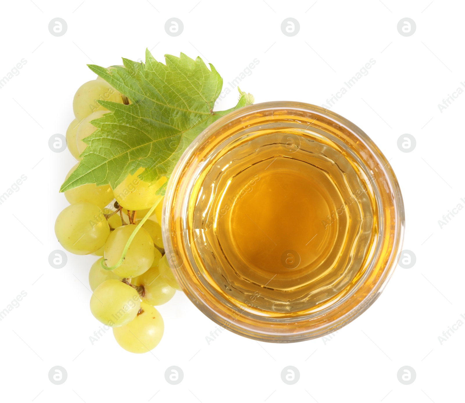 Photo of Ripe grapes and glass of tasty juice isolated on white, top view