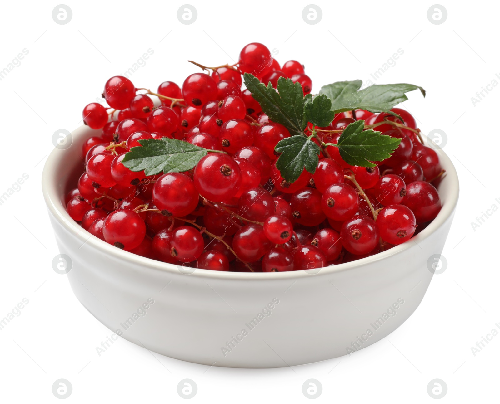 Photo of Ripe red currants with green leaves in bowl isolated on white