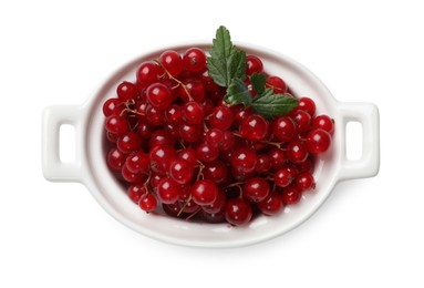 Photo of Ripe red currants with green leaves in bowl isolated on white, top view