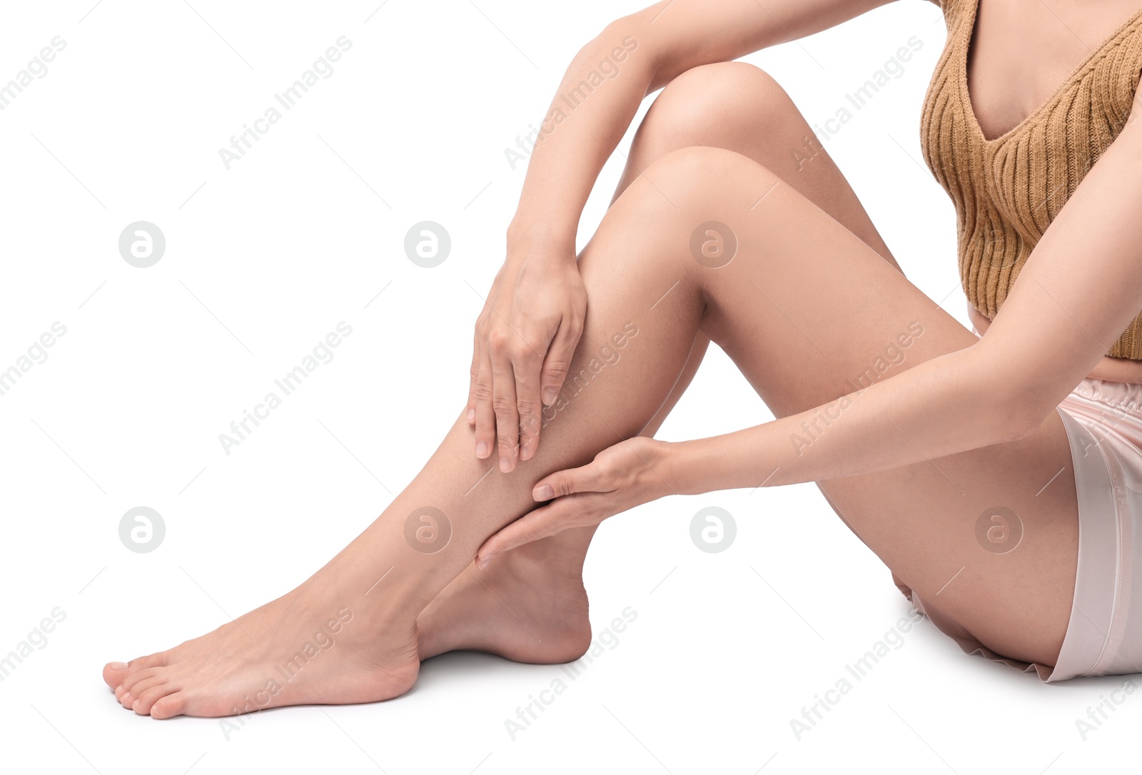 Photo of Woman touching her smooth legs on white background, closeup