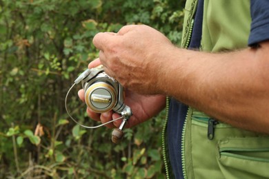 Fisherman with rod fishing near lake at summer, closeup