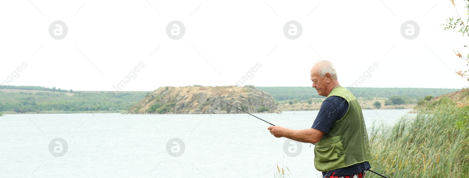 Photo of Fisherman with rod fishing near lake at summer