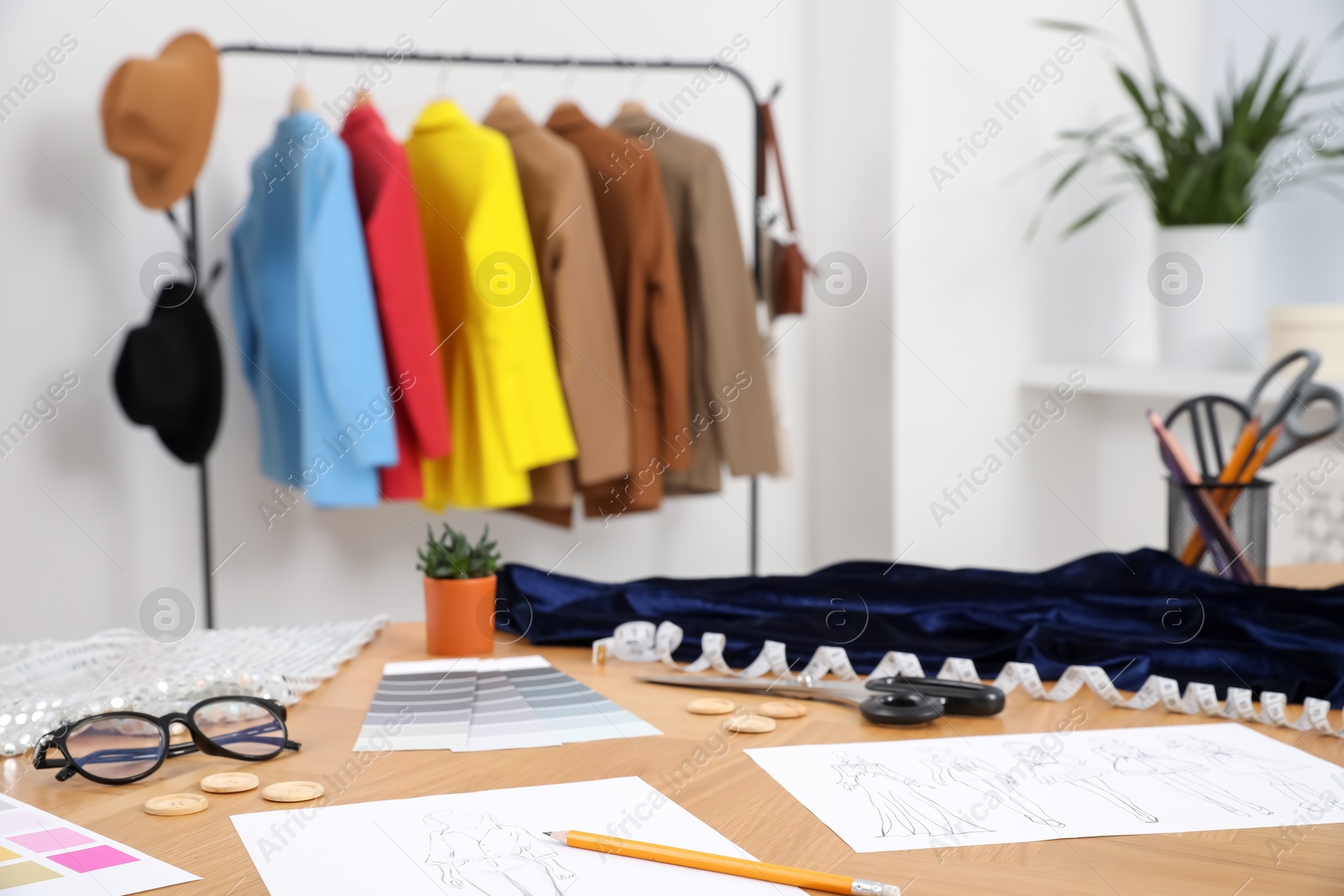 Photo of Different fashion designer`s supplies on wooden table in workshop