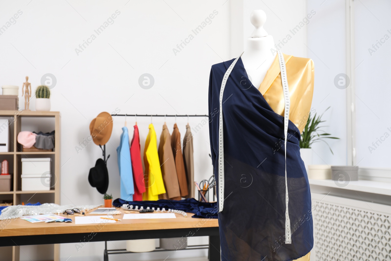 Photo of Fashion designer`s workplace with new outfit on mannequin