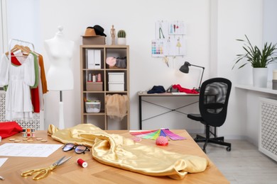 Photo of Fashion designer`s workplace with sketches of new outfits and other supplies