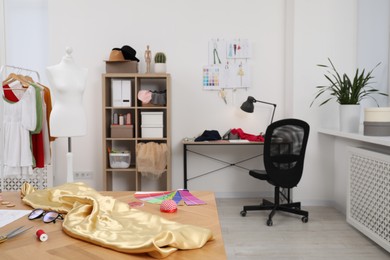 Photo of Fashion designer`s workplace with sketches of new outfits and other supplies