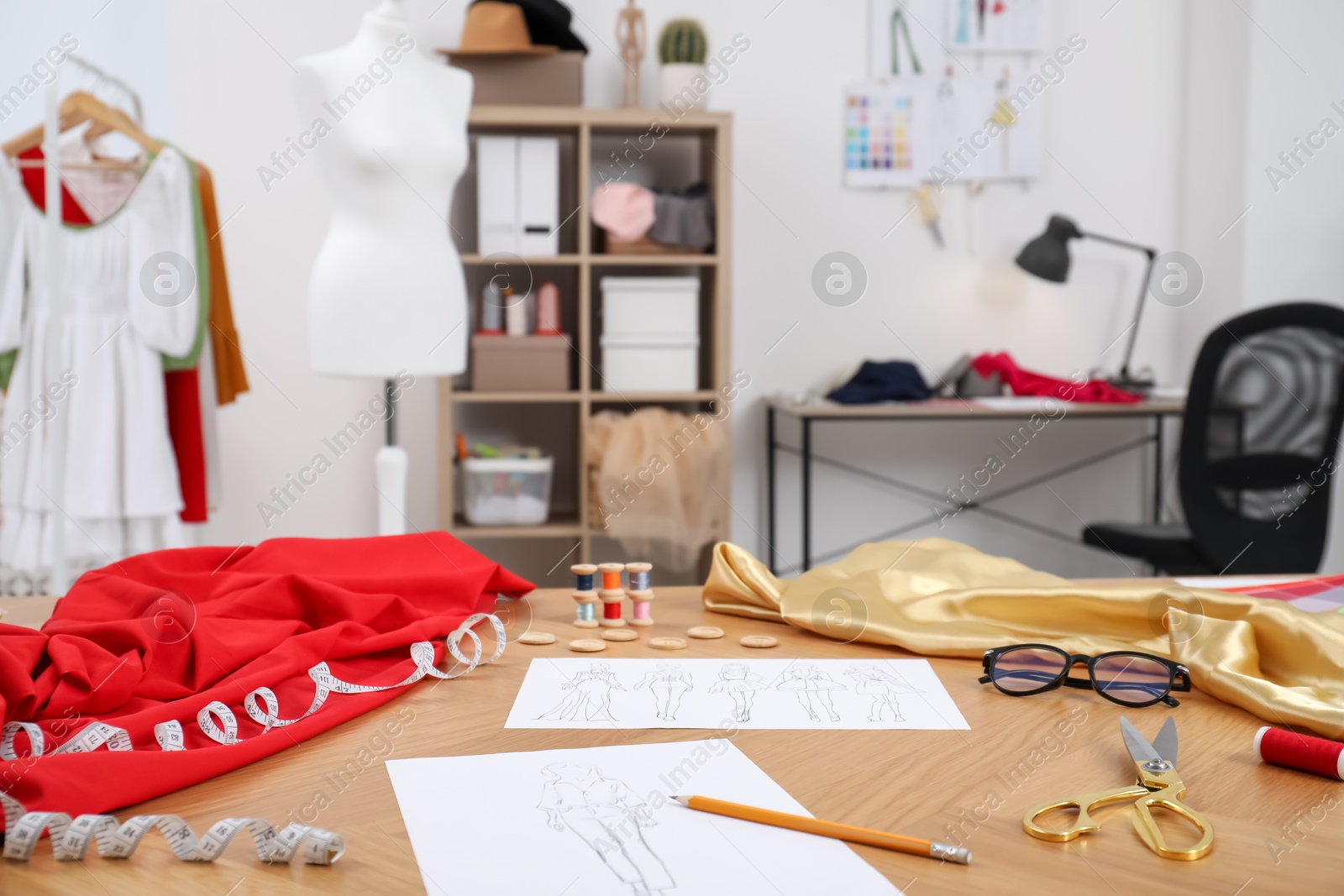 Photo of Different fashion designer`s supplies on wooden table in workshop