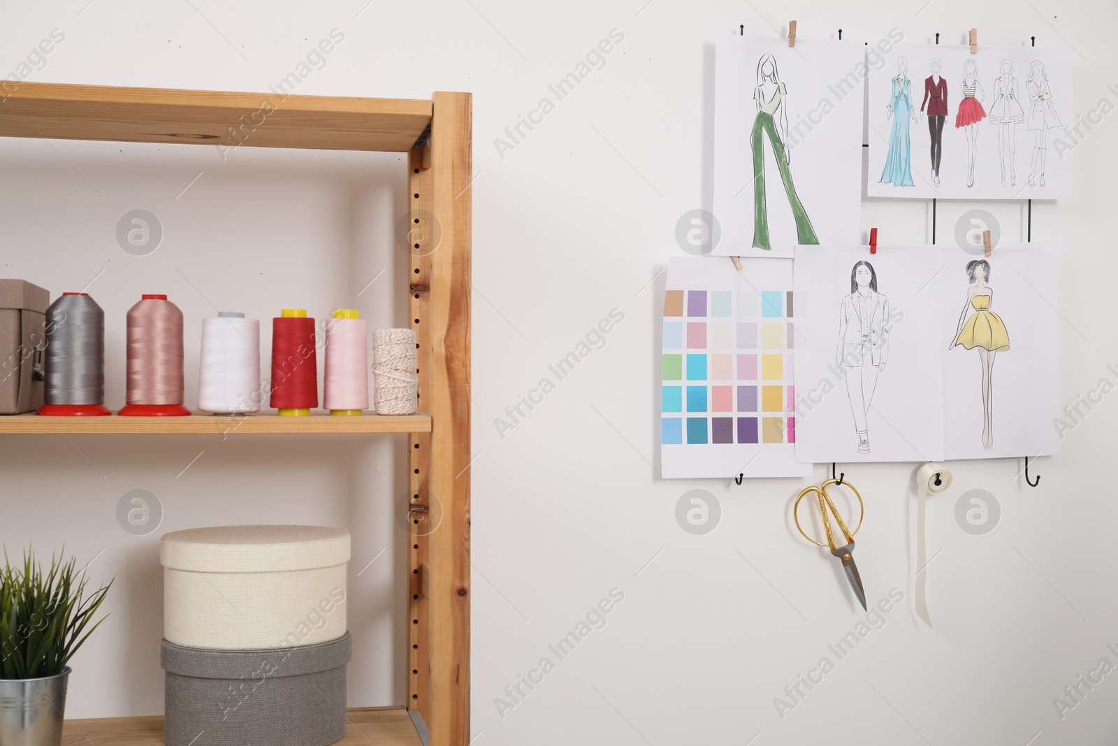 Photo of Fashion designer`s workplace with sketches of new outfits and other supplies